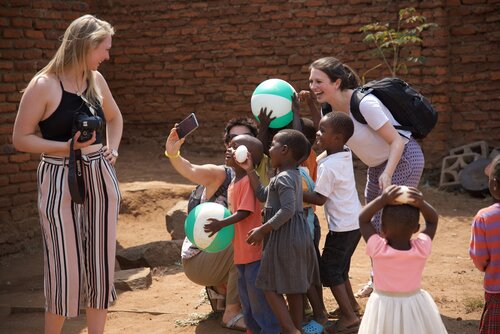 Volunteers playing with children and a beach ball