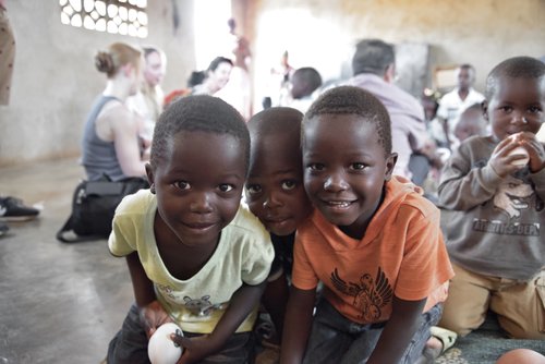 Three boys smiling together at Chikondi